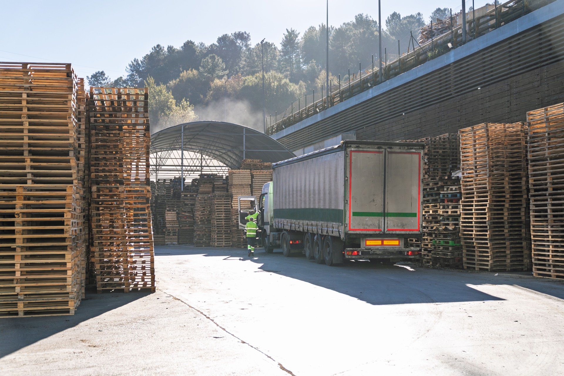 Truck loading wooden pallets at recycling industry plant